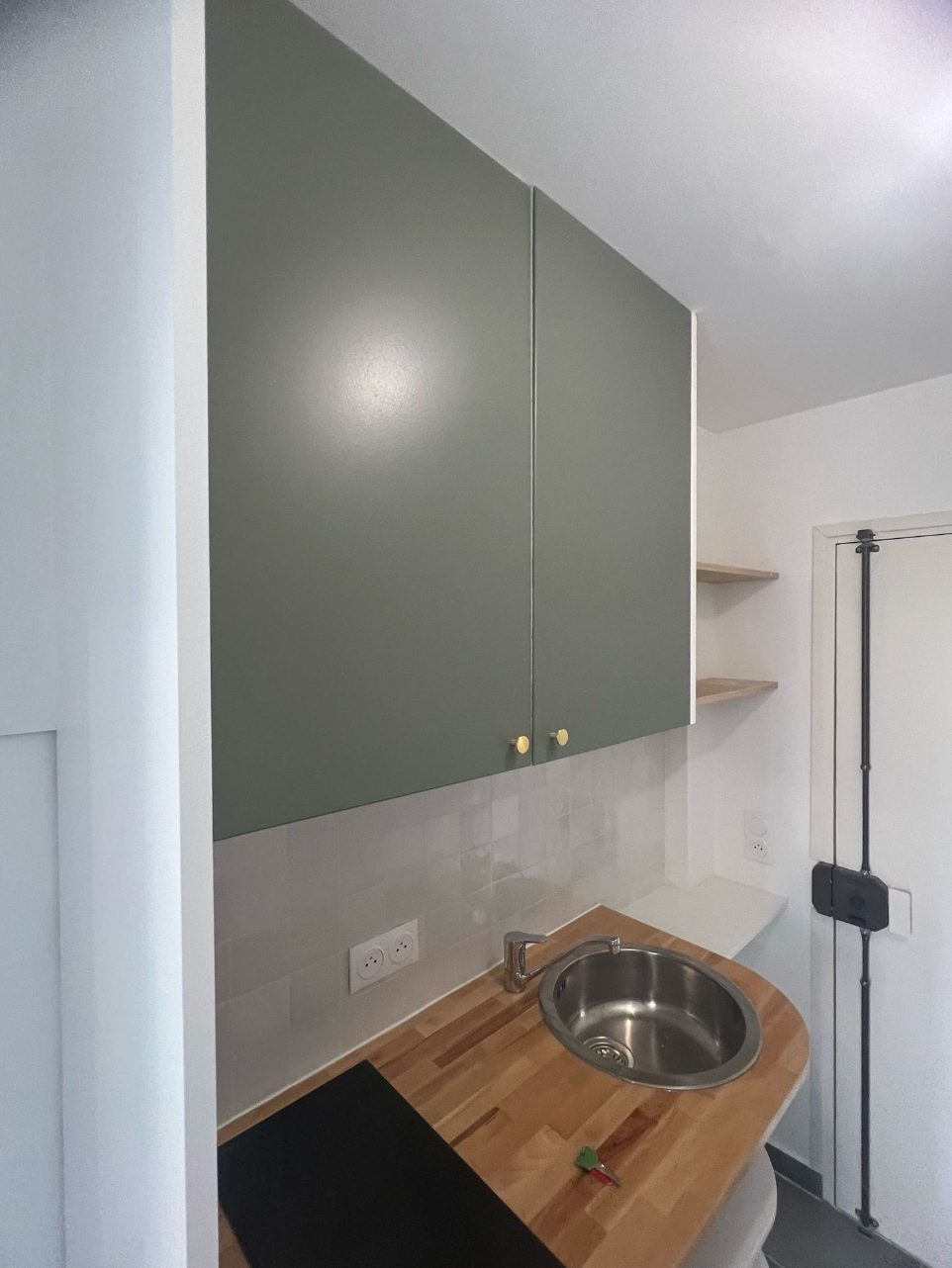 Cuisine sur mesure avec crédence grise et rangements intégrés.